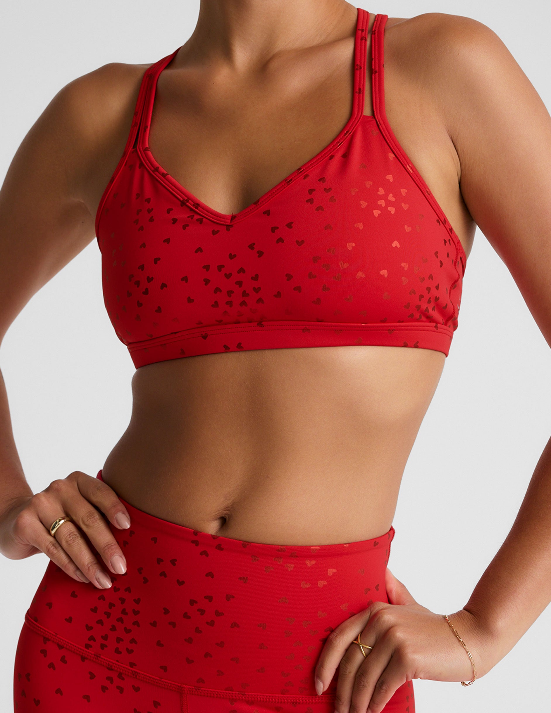 red bra top with a soft v neckline, double crossover straps and a shimmering heart pattern.